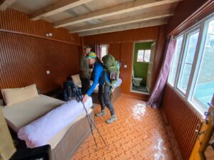“Basic mountain lodge room with wooden beds and blankets in Nepal.